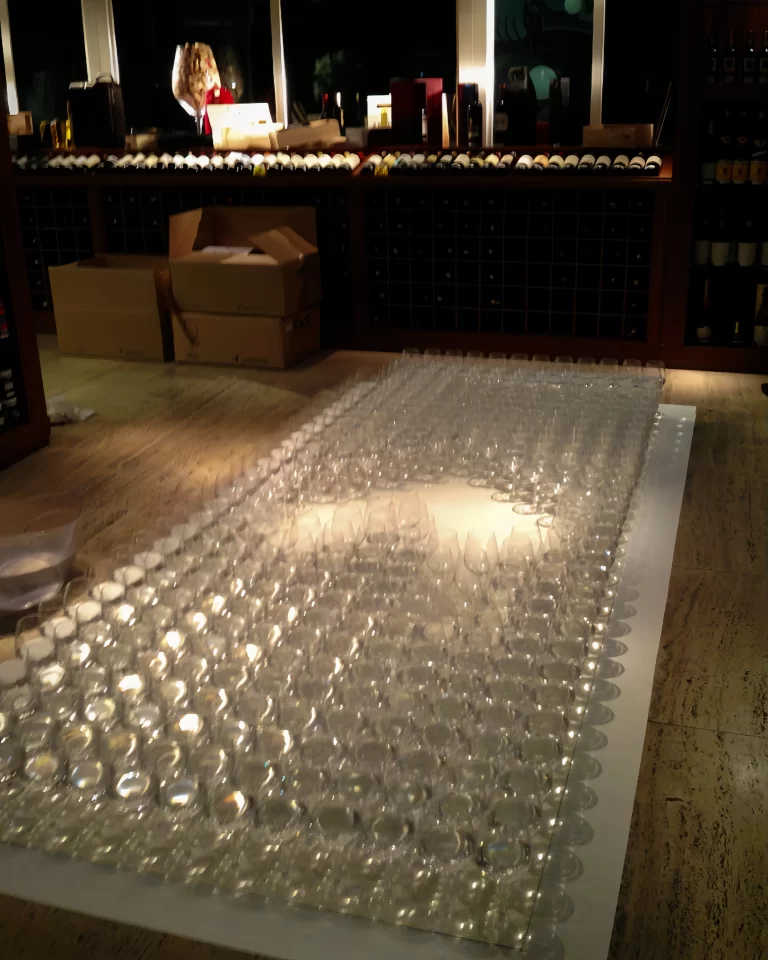Making of. Assembly of the three-dimensional carpet 
made with crystal wine glasses, by Elisabeth Abduch. 
Enoteca Amauri, Jardins, São Paulo.